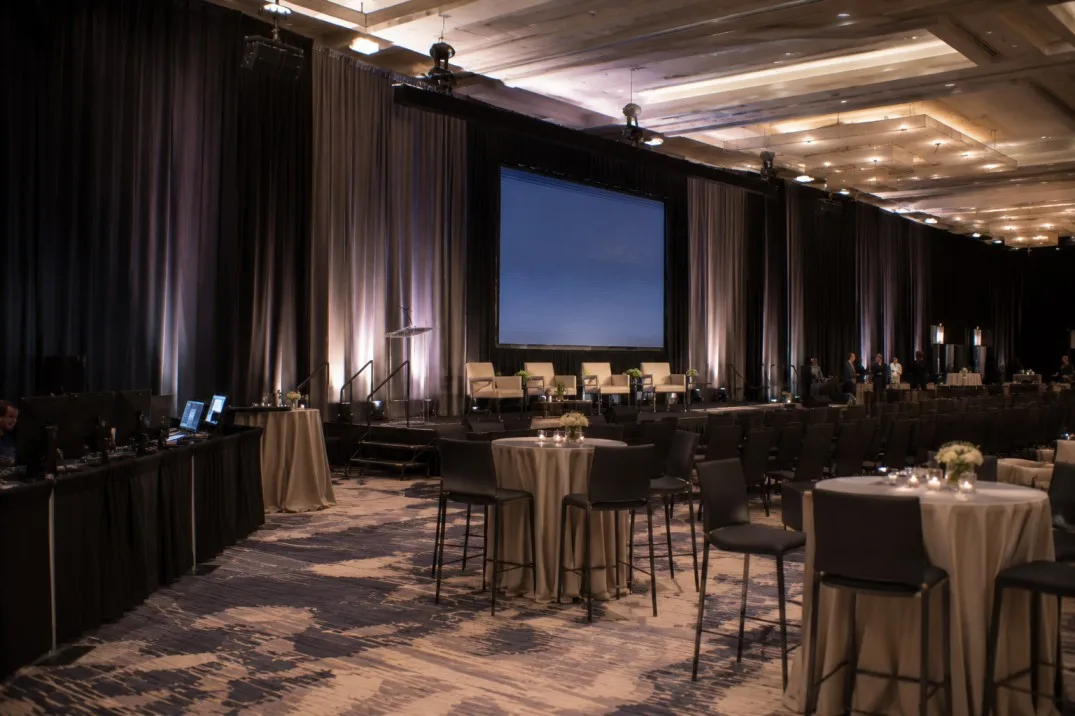 Corporate ballroom transformed with stage draping and temporary event divisions