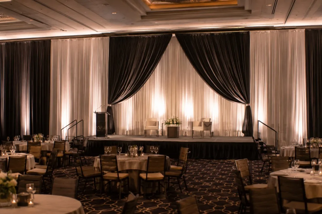 Event stage environment transformed with fabric draping and controlled backgrounds